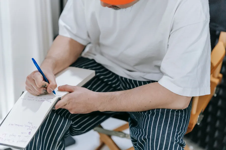A restaurant manager writing notes in a notebook at the counter